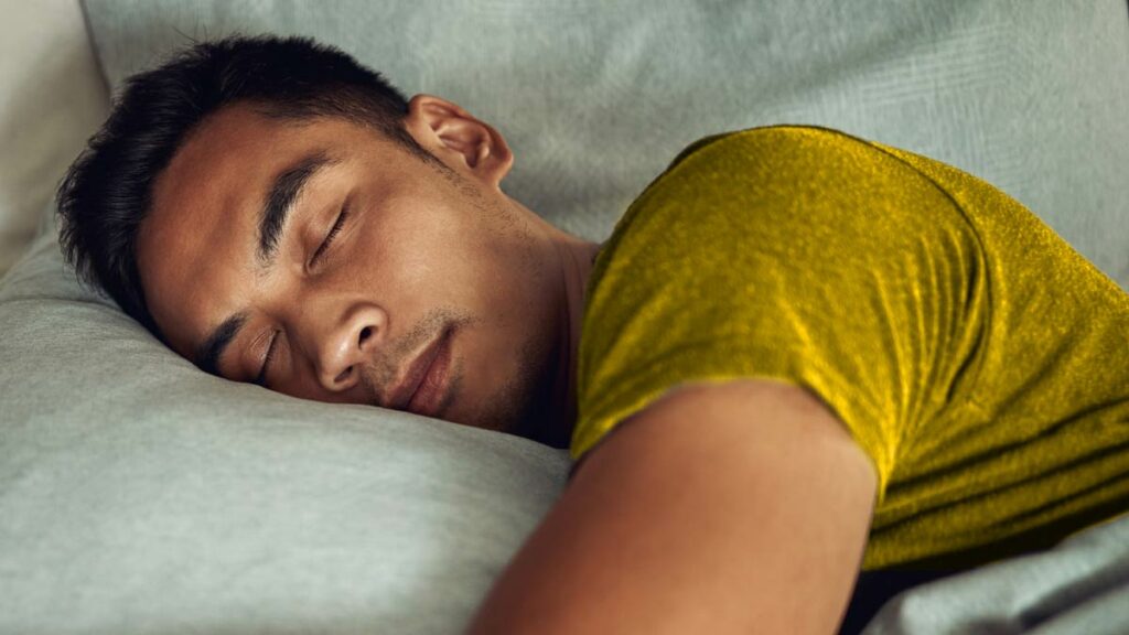 Man in a Yellow Shirt Having a Restful Night Sleep Wearing an Oral Appliance - Feature Image - 1200x675